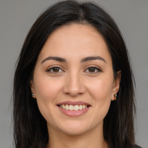 Joyful white young-adult female with long  brown hair and brown eyes