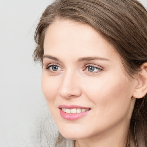 Joyful white young-adult female with long  brown hair and grey eyes