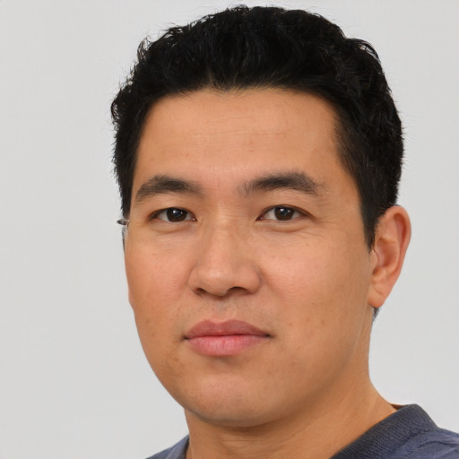Joyful asian young-adult male with short  black hair and brown eyes