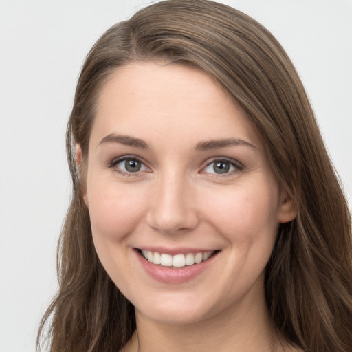 Joyful white young-adult female with long  brown hair and grey eyes