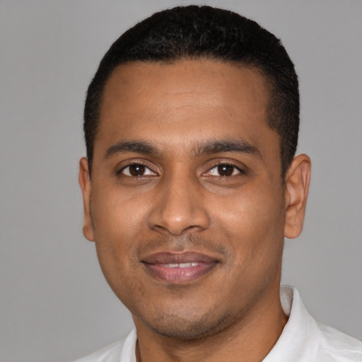 Joyful black young-adult male with short  black hair and brown eyes