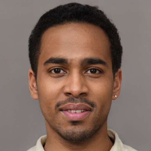 Joyful black young-adult male with short  black hair and brown eyes