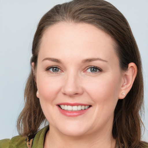 Joyful white young-adult female with medium  brown hair and grey eyes