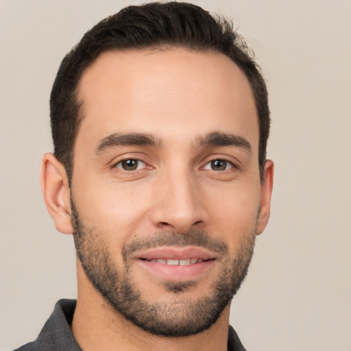 Joyful white young-adult male with short  black hair and brown eyes