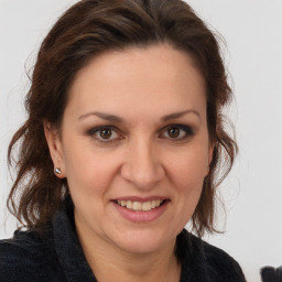 Joyful white adult female with long  brown hair and brown eyes