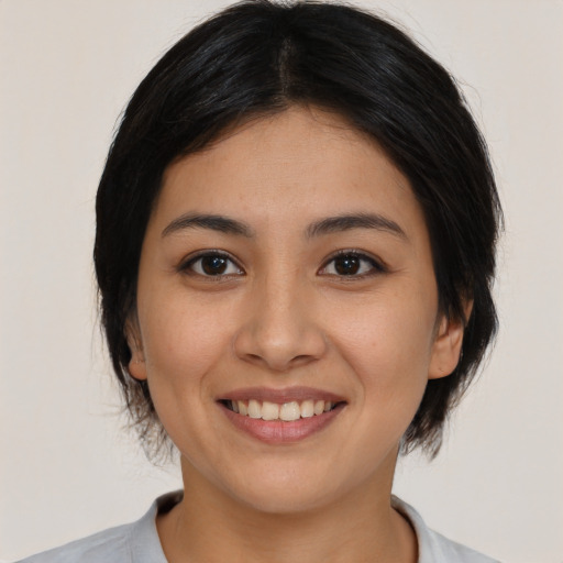 Joyful asian young-adult female with medium  black hair and brown eyes