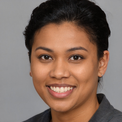 Joyful latino young-adult female with short  brown hair and brown eyes