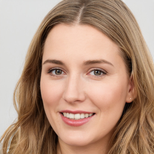 Joyful white young-adult female with long  brown hair and green eyes