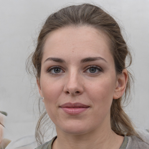 Joyful white young-adult female with medium  brown hair and grey eyes