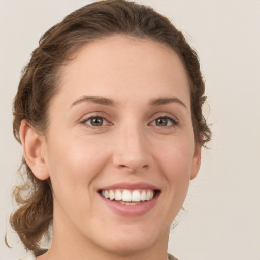 Joyful white young-adult female with medium  brown hair and green eyes