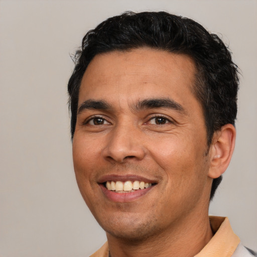 Joyful latino young-adult male with short  black hair and brown eyes