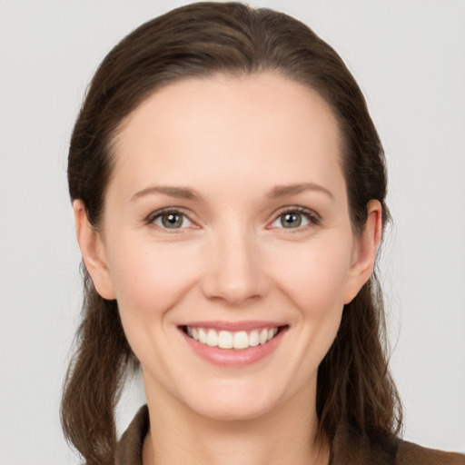 Joyful white young-adult female with long  brown hair and grey eyes