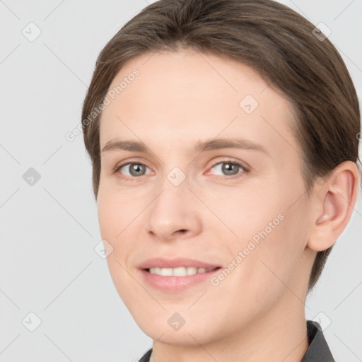 Joyful white young-adult female with short  brown hair and grey eyes