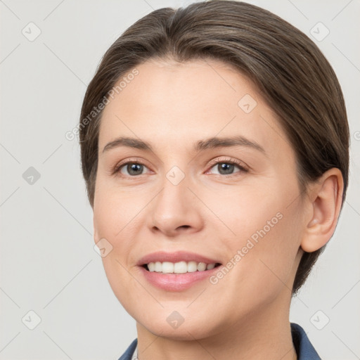 Joyful white young-adult female with medium  brown hair and grey eyes