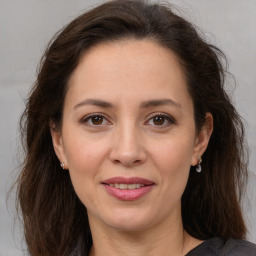 Joyful white adult female with long  brown hair and brown eyes