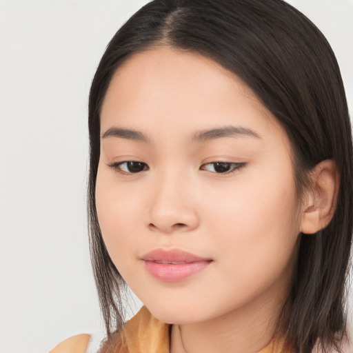 Joyful asian young-adult female with long  brown hair and brown eyes