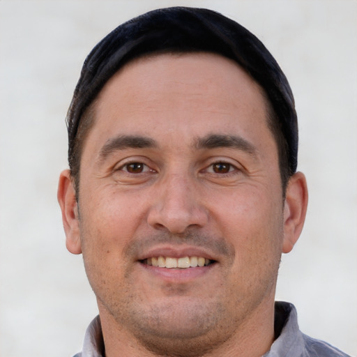 Joyful white adult male with short  black hair and brown eyes