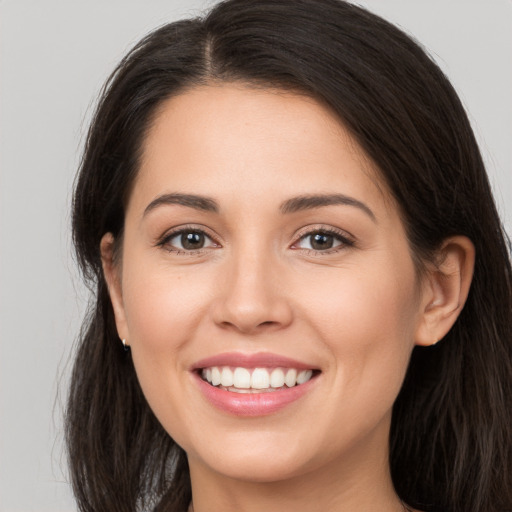 Joyful white young-adult female with long  brown hair and brown eyes