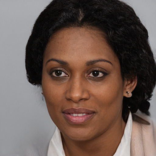 Joyful black adult female with medium  black hair and brown eyes