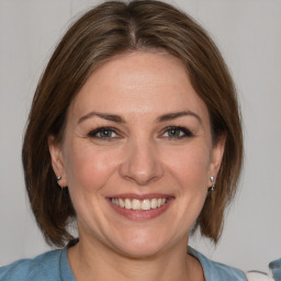 Joyful white adult female with medium  brown hair and brown eyes