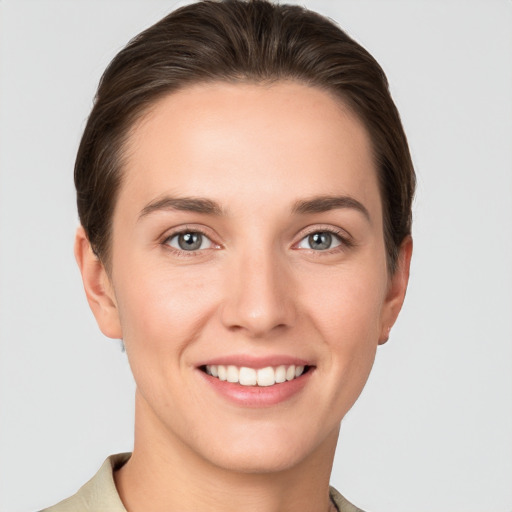 Joyful white young-adult female with short  brown hair and grey eyes