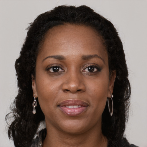 Joyful black adult female with long  brown hair and brown eyes