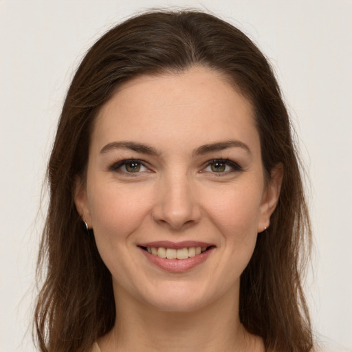 Joyful white young-adult female with long  brown hair and green eyes