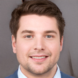 Joyful white young-adult male with short  brown hair and grey eyes