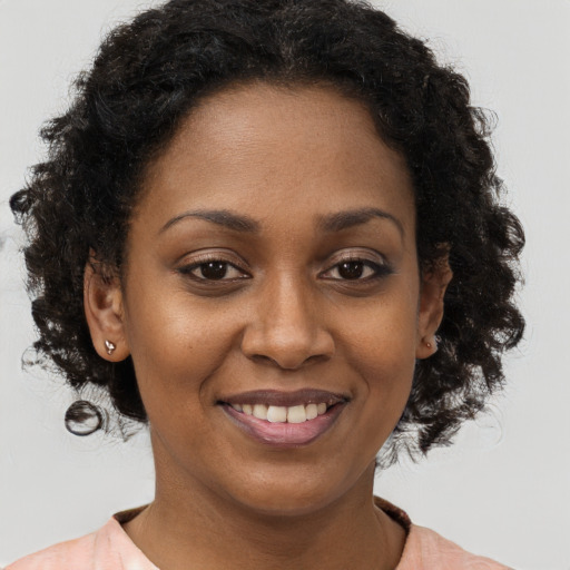 Joyful black young-adult female with medium  brown hair and brown eyes