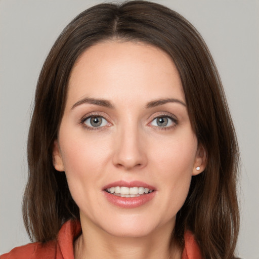 Joyful white young-adult female with long  brown hair and grey eyes