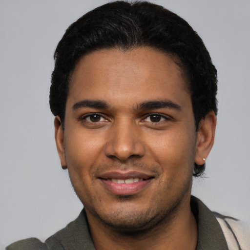 Joyful latino young-adult male with short  black hair and brown eyes