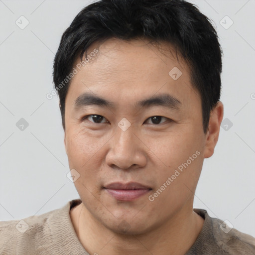 Joyful asian young-adult male with short  black hair and brown eyes