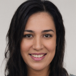 Joyful latino young-adult female with long  brown hair and brown eyes