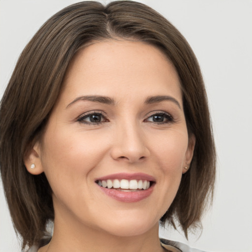 Joyful white young-adult female with medium  brown hair and grey eyes