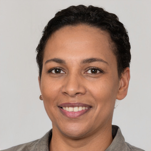 Joyful latino adult female with short  black hair and brown eyes