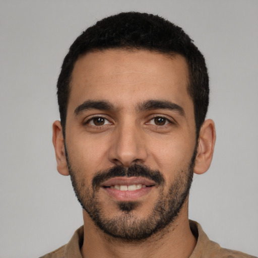 Joyful latino young-adult male with short  black hair and brown eyes