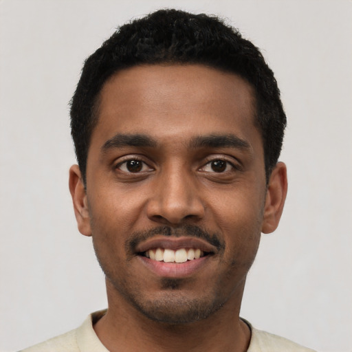 Joyful black young-adult male with short  black hair and brown eyes