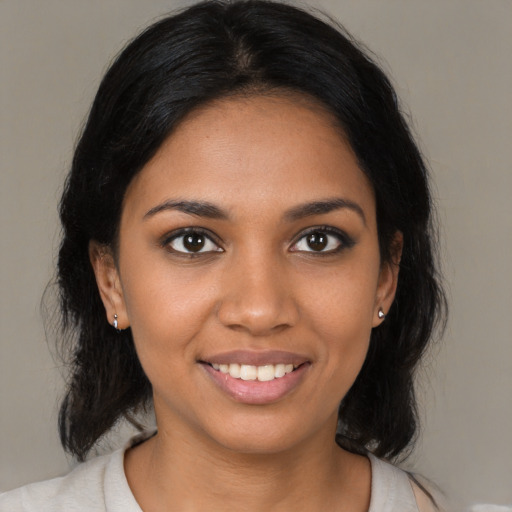 Joyful black young-adult female with medium  black hair and brown eyes