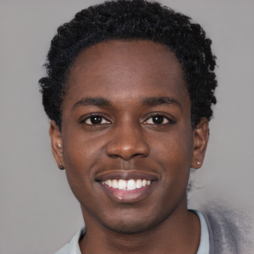 Joyful black young-adult male with short  brown hair and brown eyes