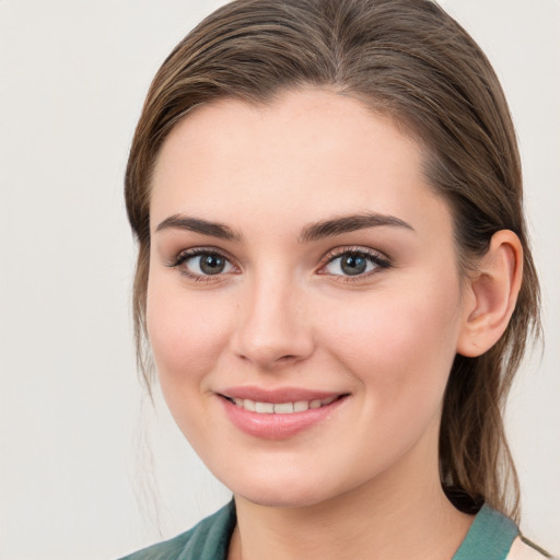 Joyful white young-adult female with medium  brown hair and grey eyes