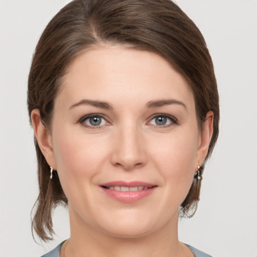 Joyful white young-adult female with medium  brown hair and grey eyes