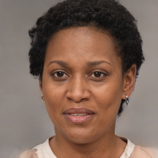 Joyful black adult female with short  brown hair and brown eyes