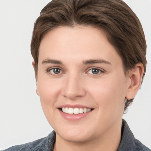 Joyful white young-adult female with short  brown hair and grey eyes