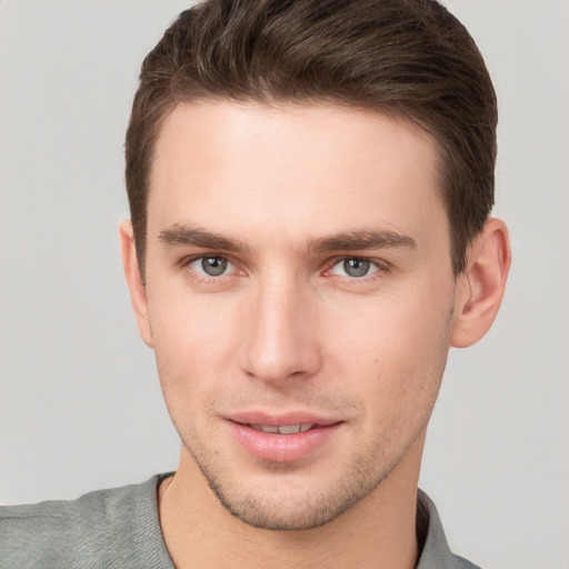 Joyful white young-adult male with short  brown hair and grey eyes