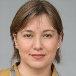 Joyful white adult female with medium  brown hair and grey eyes