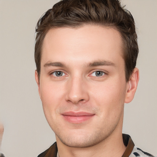 Joyful white young-adult male with short  brown hair and grey eyes