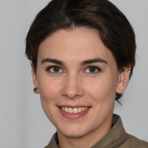 Joyful white young-adult female with medium  brown hair and grey eyes