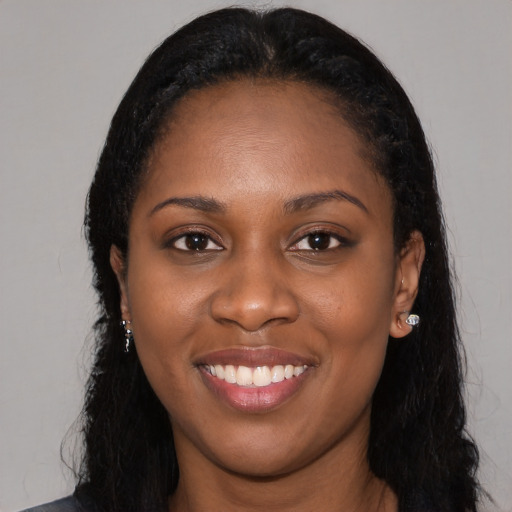 Joyful black young-adult female with long  black hair and brown eyes