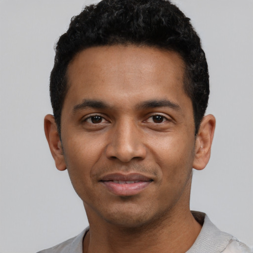 Joyful latino young-adult male with short  black hair and brown eyes