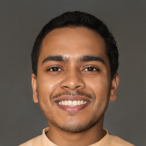 Joyful latino young-adult male with short  black hair and brown eyes